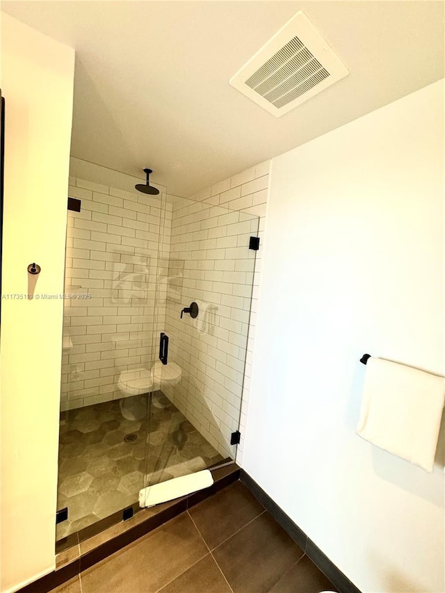 bathroom with tile patterned flooring and a shower with shower door