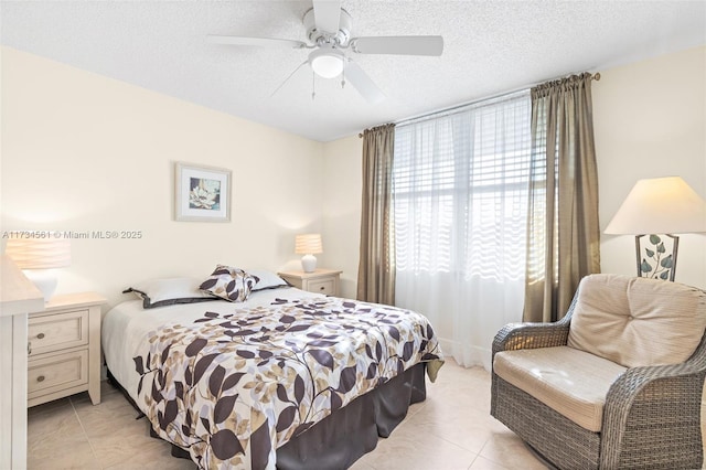 tiled bedroom featuring ceiling fan and a textured ceiling