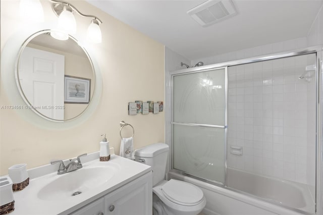 full bathroom featuring enclosed tub / shower combo, vanity, and toilet