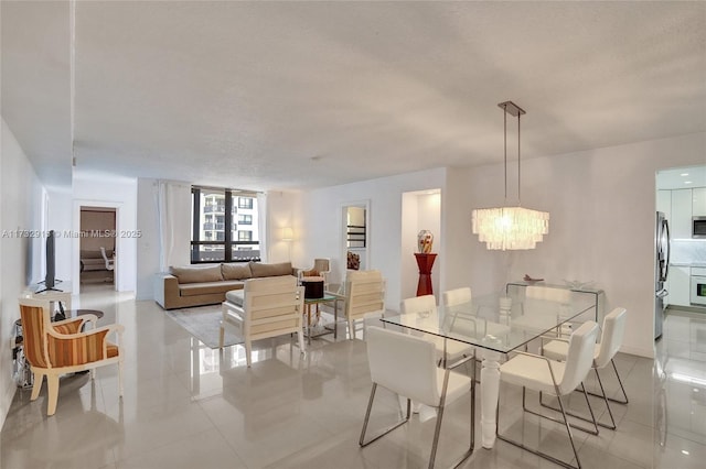 dining space with an inviting chandelier, light tile patterned floors, and a textured ceiling