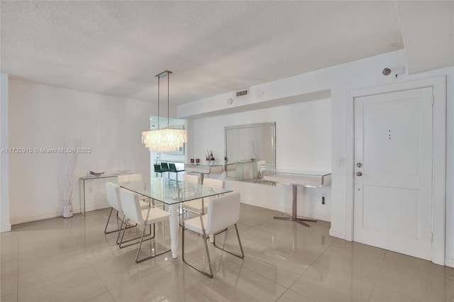 tiled dining space featuring a textured ceiling and a notable chandelier