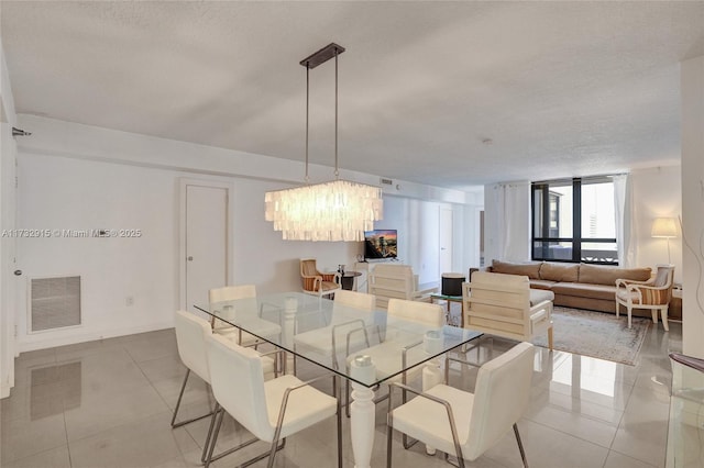 dining space with light tile patterned floors, a textured ceiling, and a chandelier