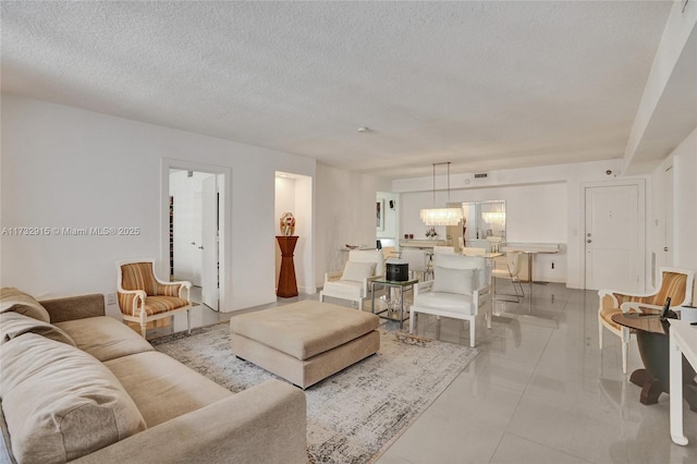 living room featuring light tile patterned flooring and a textured ceiling