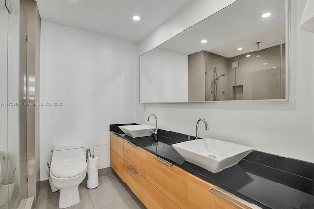 bathroom with vanity, walk in shower, tile patterned floors, and toilet