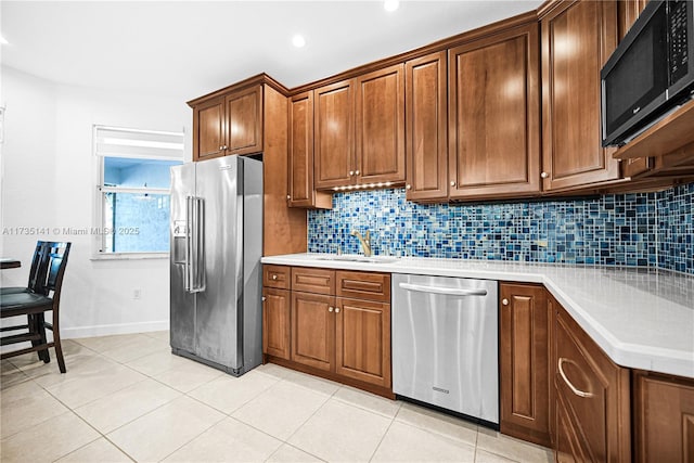 kitchen featuring light tile patterned flooring, stainless steel appliances, sink, and decorative backsplash