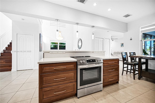 kitchen with stainless steel range with electric stovetop, light tile patterned floors, and pendant lighting