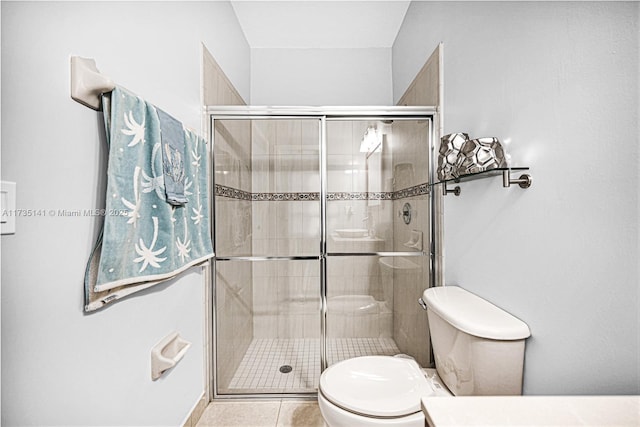 bathroom featuring an enclosed shower, tile patterned floors, and toilet