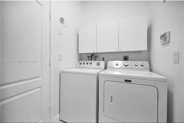 laundry room featuring cabinets and separate washer and dryer