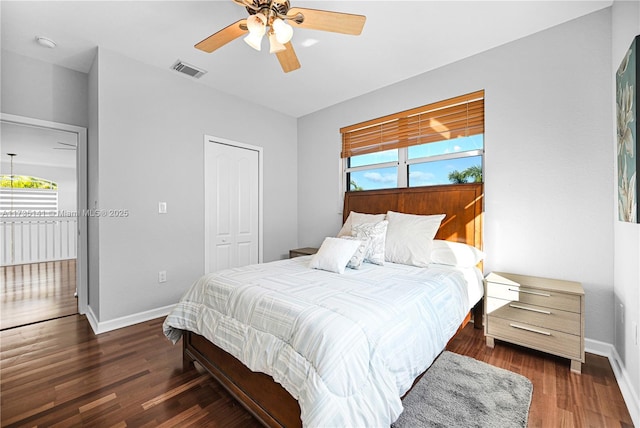 bedroom featuring dark hardwood / wood-style floors, ceiling fan, and a closet