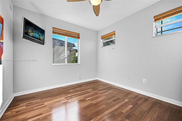 empty room with ceiling fan, hardwood / wood-style flooring, and a healthy amount of sunlight