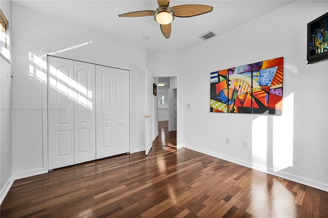 interior space with dark wood-type flooring, ceiling fan, and a closet