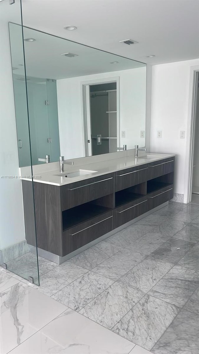 bathroom with vanity and a shower with door