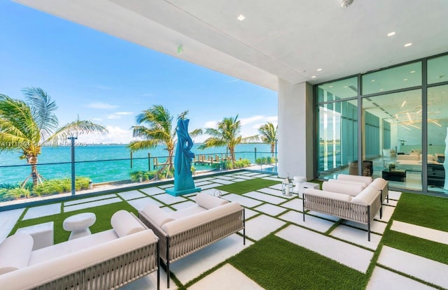 balcony featuring a water view and an outdoor living space