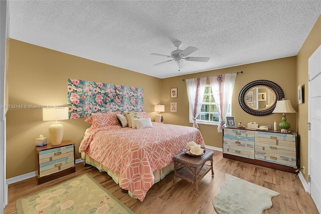 bedroom featuring hardwood / wood-style flooring, ceiling fan, and a textured ceiling