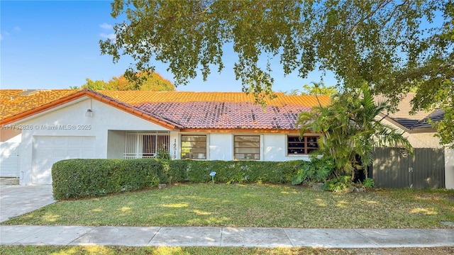 view of front of property featuring a garage and a front lawn