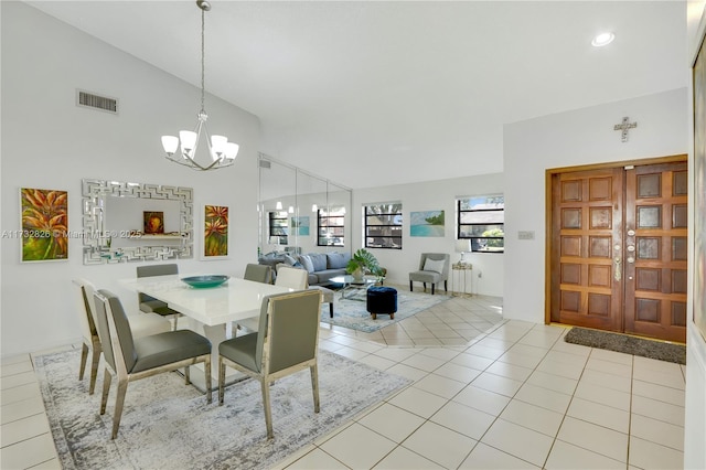 dining space with light tile patterned floors, high vaulted ceiling, and a chandelier