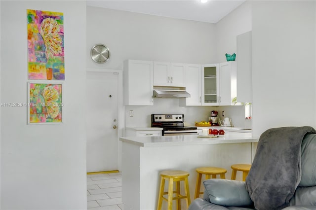 kitchen featuring white cabinetry, a breakfast bar, electric range, and kitchen peninsula