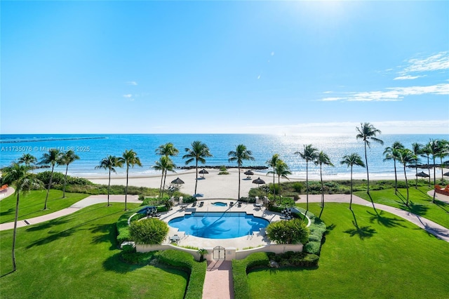 view of pool with a view of the beach, a yard, a patio area, and a water view