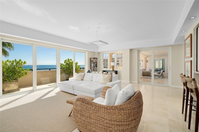 tiled living room featuring a water view