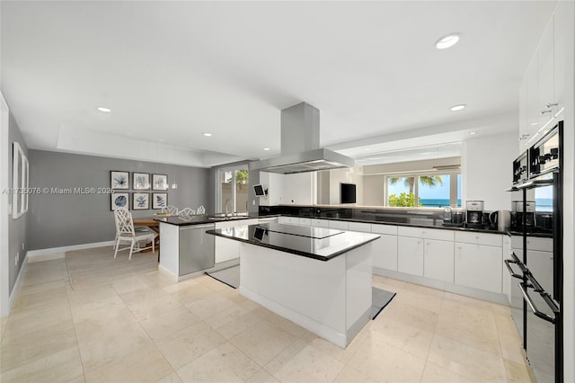 kitchen featuring white cabinetry, island exhaust hood, kitchen peninsula, and a kitchen island