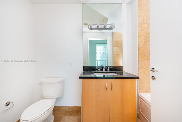 bathroom featuring vanity, a bathing tub, and toilet