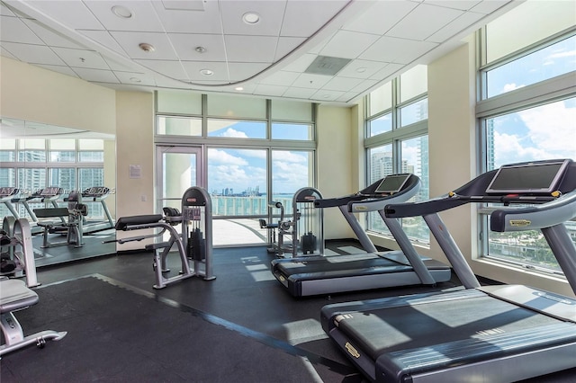 workout area with a paneled ceiling and a towering ceiling