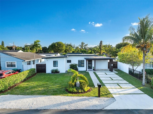 ranch-style house featuring a garage and a front lawn