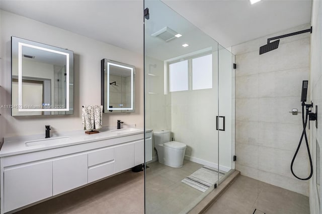 bathroom with tile patterned floors, vanity, toilet, and a shower with door