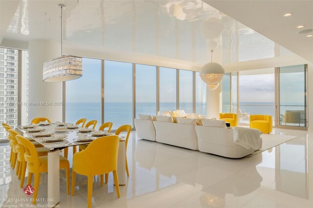 bedroom featuring an inviting chandelier, access to outside, and a water view