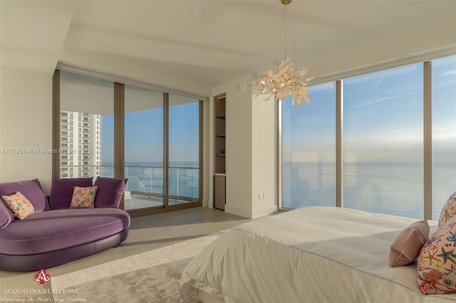 bedroom with a water view, access to exterior, an inviting chandelier, and multiple windows