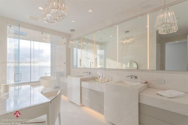 bathroom with vanity, a chandelier, and separate shower and tub