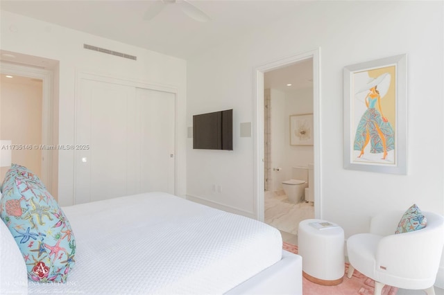 bedroom featuring ceiling fan, ensuite bath, and a closet