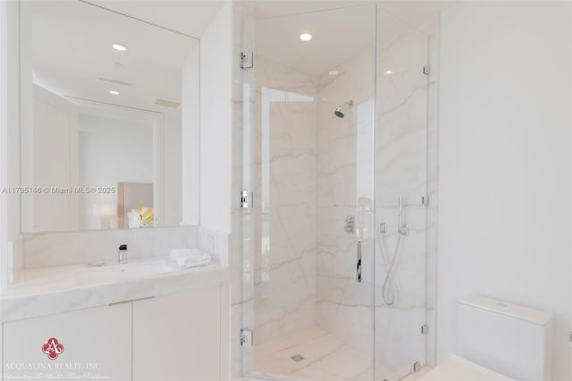 bathroom with an enclosed shower, vanity, and toilet