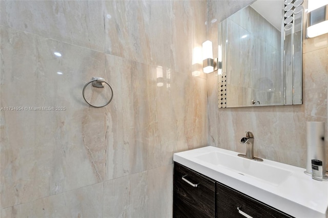 bathroom featuring tile walls, a tile shower, and vanity