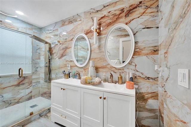 bathroom with walk in shower, vanity, and tile walls