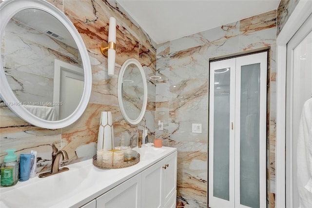 bathroom featuring vanity and tile walls