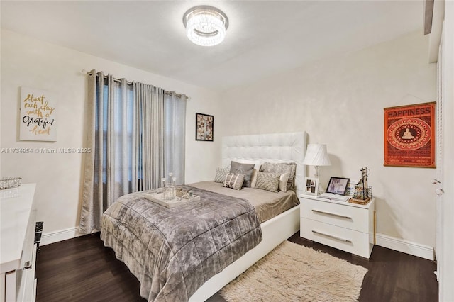 bedroom with baseboards and dark wood-style flooring