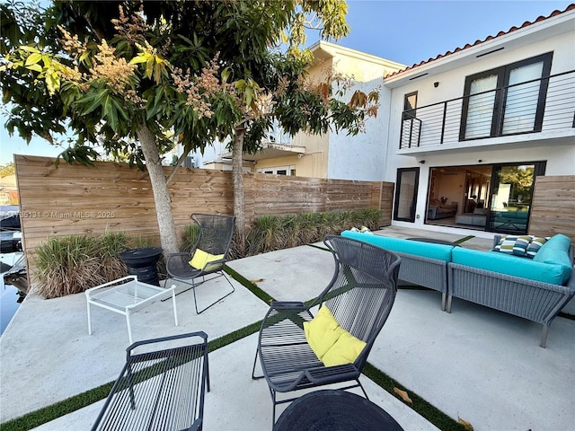 view of patio with outdoor lounge area and a balcony