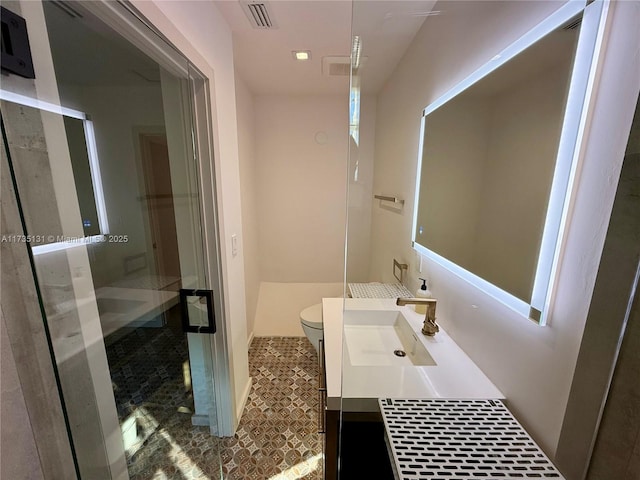 bathroom with walk in shower, vanity, and toilet