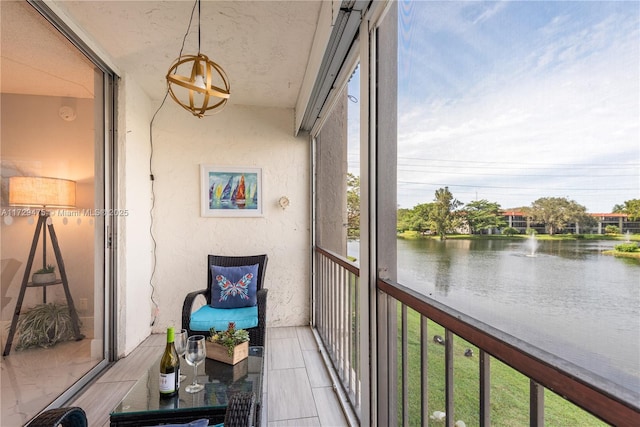 sunroom featuring a water view