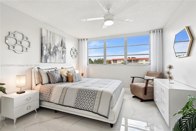 bedroom featuring ceiling fan and a textured ceiling