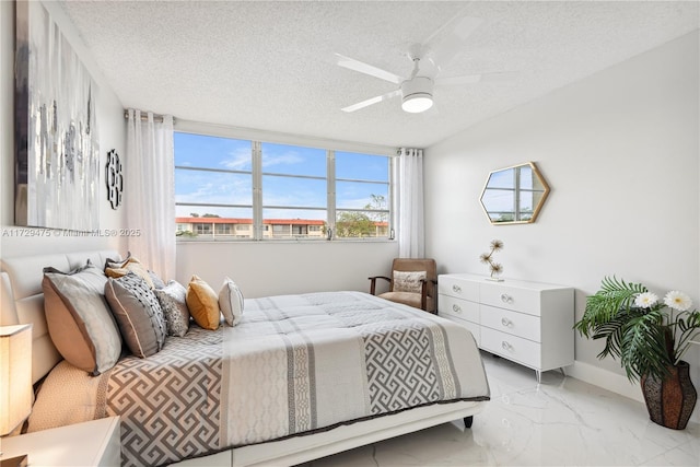 bedroom with ceiling fan and a textured ceiling