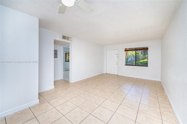 spare room with light tile patterned floors, electric panel, a textured ceiling, and ceiling fan