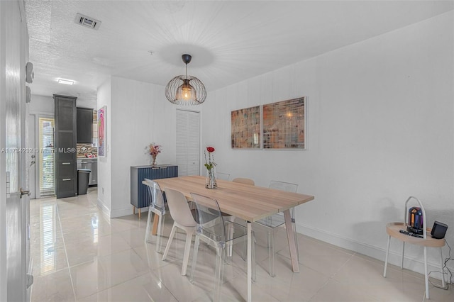 tiled dining room with a textured ceiling