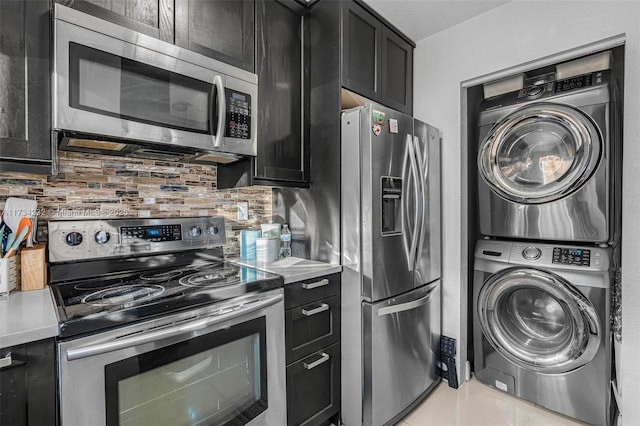 kitchen with stainless steel appliances, stacked washer and clothes dryer, and backsplash