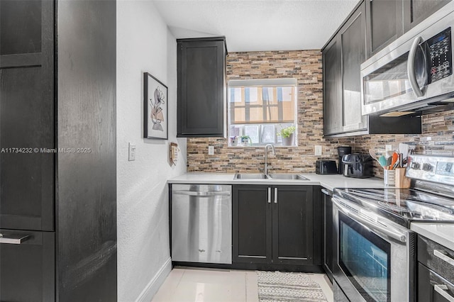 kitchen with sink, light tile patterned floors, appliances with stainless steel finishes, tasteful backsplash, and a textured ceiling