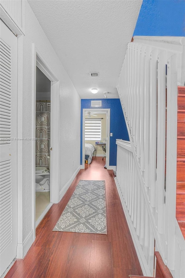 hall featuring hardwood / wood-style flooring and a textured ceiling