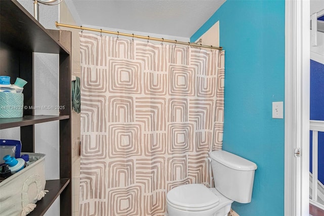 bathroom featuring a textured ceiling and toilet