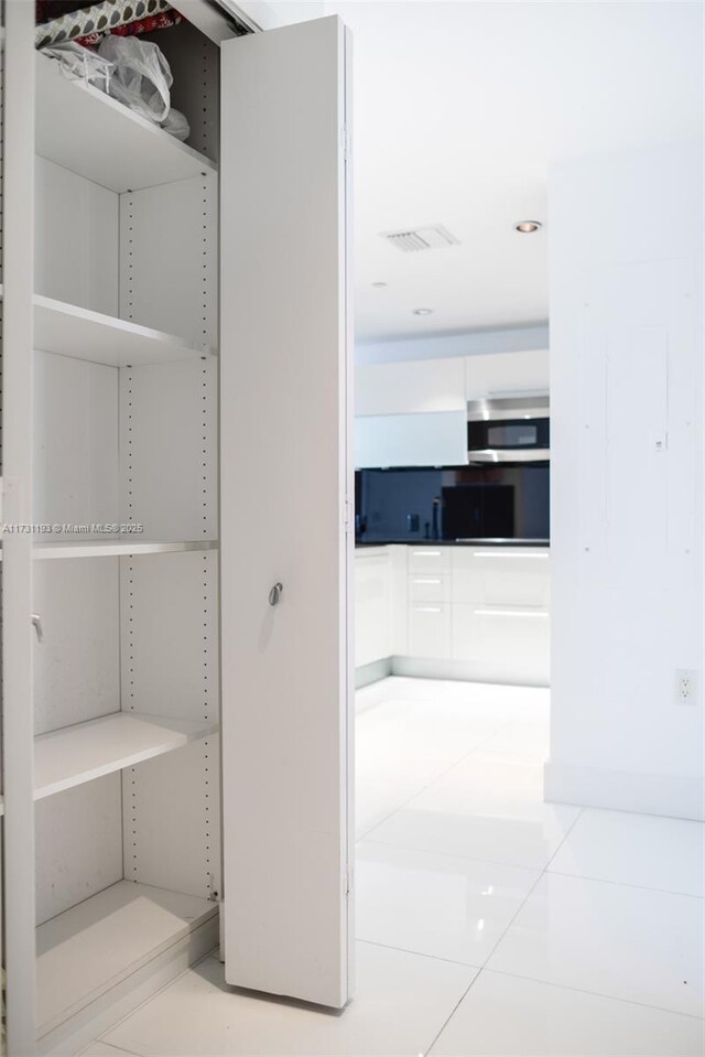 kitchen featuring a breakfast bar area, appliances with stainless steel finishes, white cabinets, decorative backsplash, and kitchen peninsula