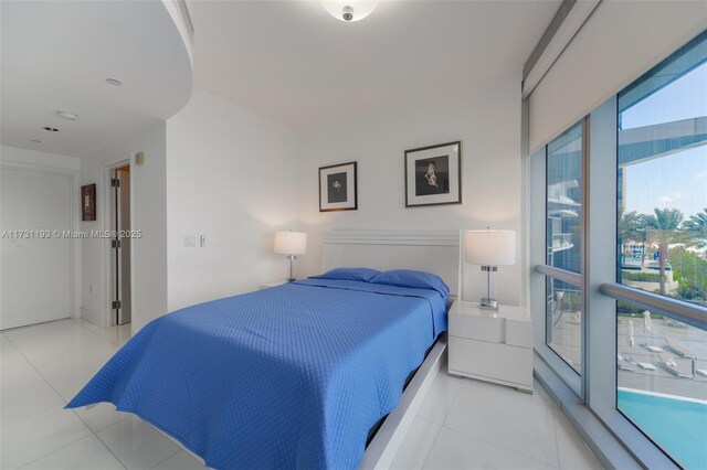 bedroom featuring light tile patterned flooring and a water view